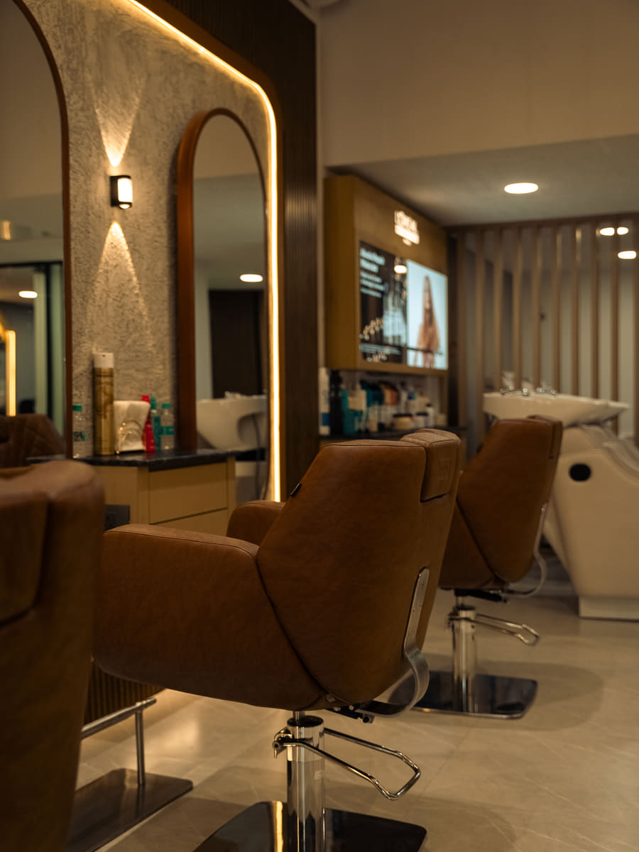 Styling chairs in the foreground with the white wash basins visible at the back of the room.